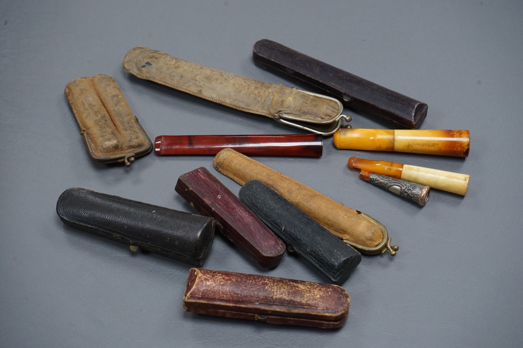 Twelve mixed cigarette and cheroot holders, some Cherry Amber, some with original cases